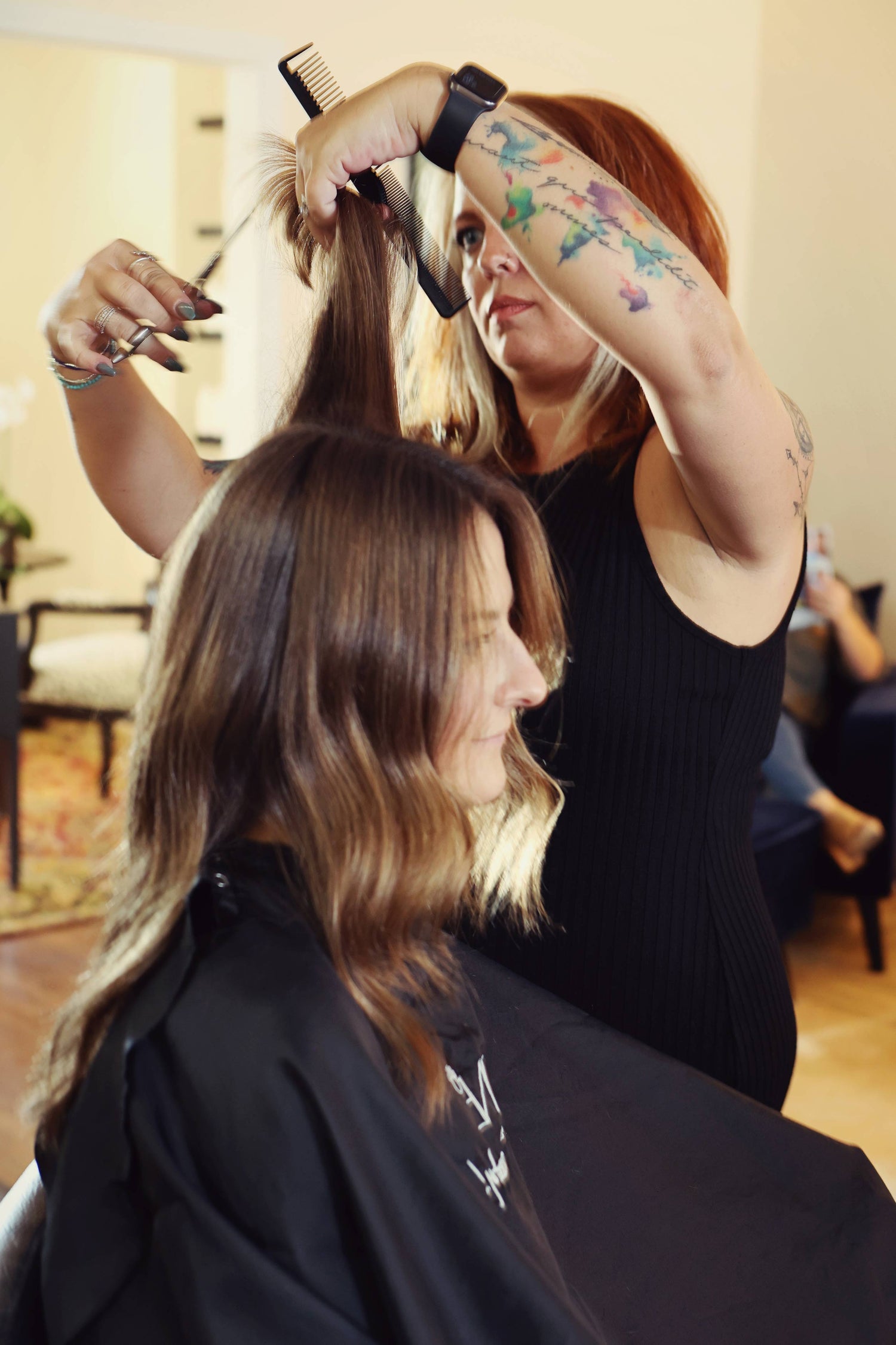 Hair stylist Sam McBride trimming a client’s hair 